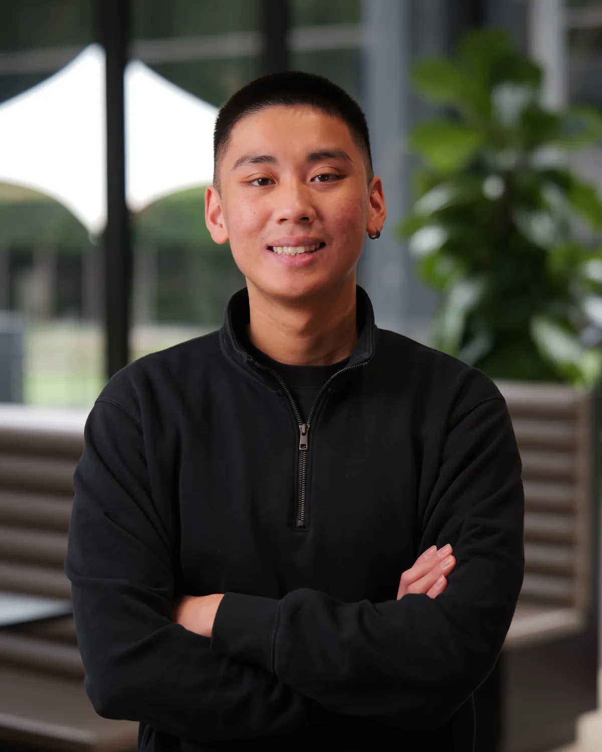 Jordan Pham smiling with his arms crossed